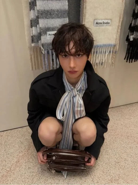 Ảnh Gun Atthaphan Phunsawat ngồi ôm túi xách tại cửa hàng Acne Studios