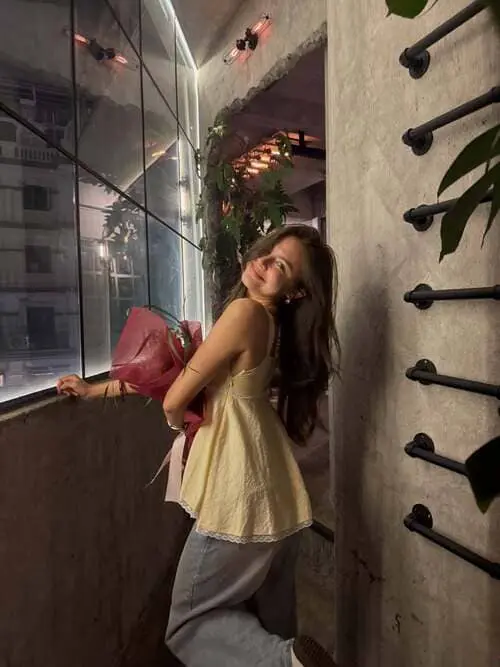 marissa-lloyd-hinh-anh-3 Marissa Lloyd mặc váy vàng ôm bó hoa hồng, quay lại cười tươi bên ban công quán