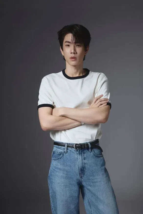 Off Jumpol Adulkittiporn khoanh tay mặc áo trắng viền đen quần jeans