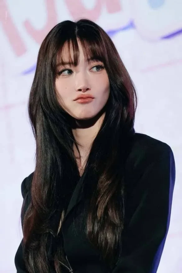 Ảnh JingJing Yu đưa mắt sang bên, blazer đen, tóc mái thưa buông xõa