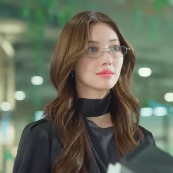 Ảnh JingJing Yu trong cảnh phim EWB, kính gọng bạc và khăn lụa đen quấn cổ