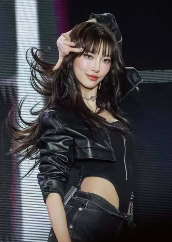 Ảnh JingJing Yu vuốt tóc trên sân khấu, croptop da đen và jeans xám