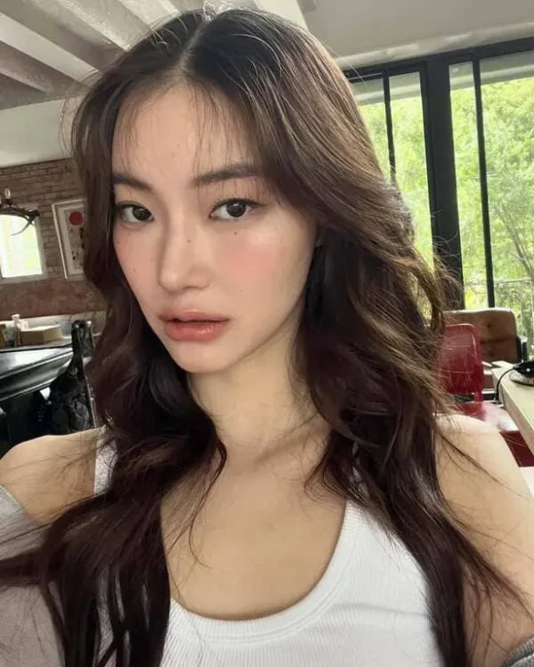 Ảnh JingJing Yu selfie mộc trong quán, áo ba lỗ trắng và tóc xoăn nhẹ