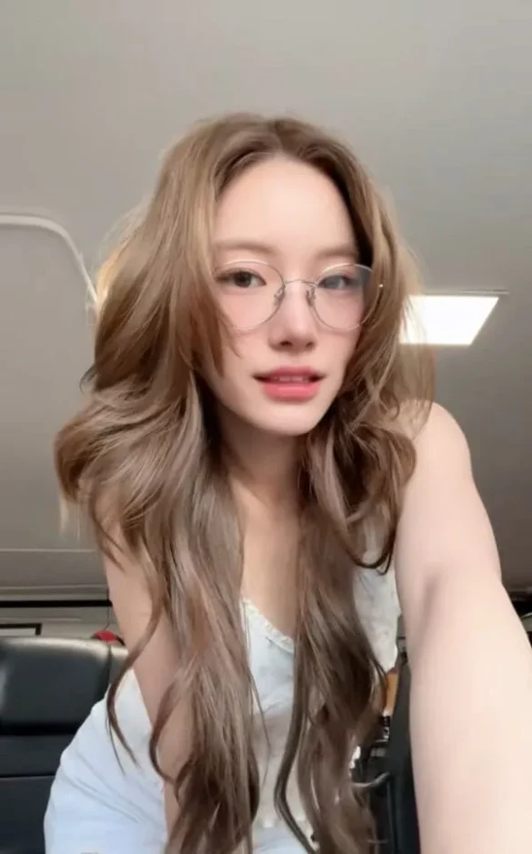 Ảnh JingJing Yu quay video trong xe, kính tròn và áo hai dây