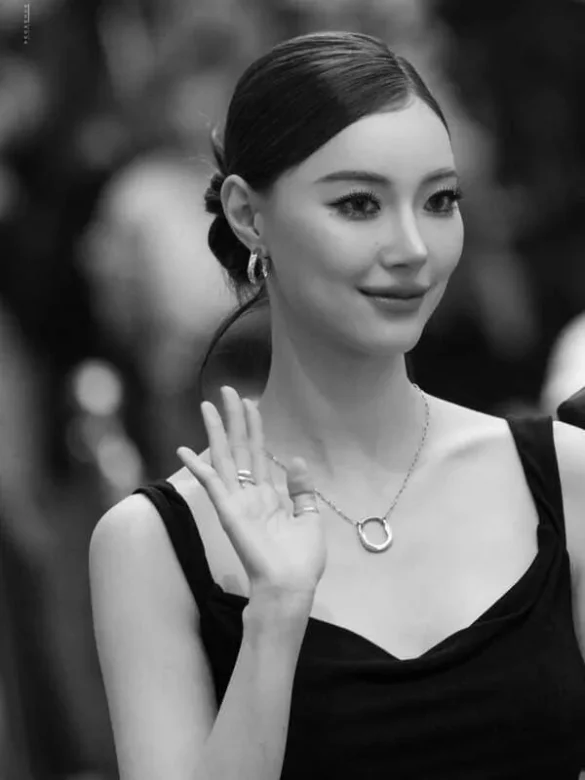 Ảnh JingJing Yu vẫy tay chào tại sự kiện, tóc búi thấp và đầm hai dây đen