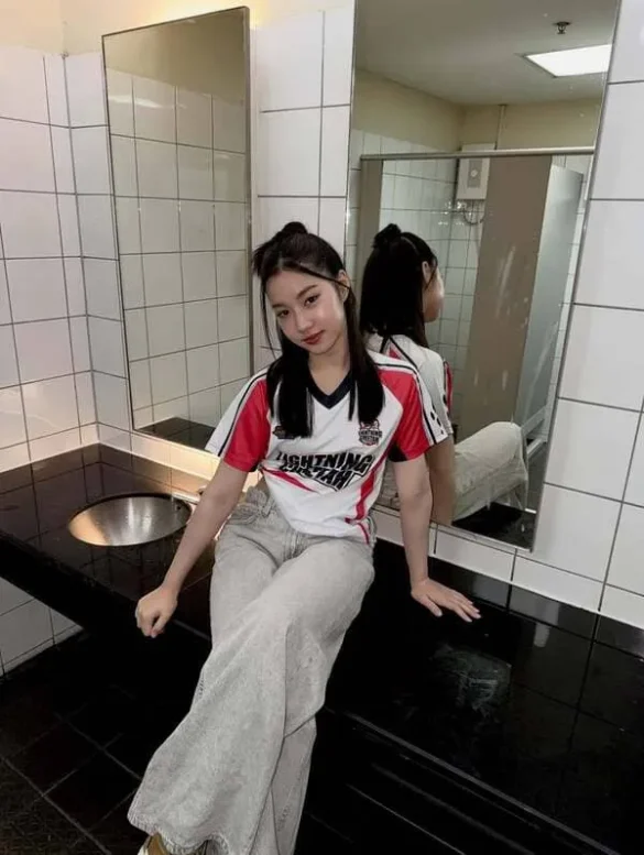 Pang Phichayada Chonpaipimolrut mặc áo thể thao ngồi trong nhà vệ sinh